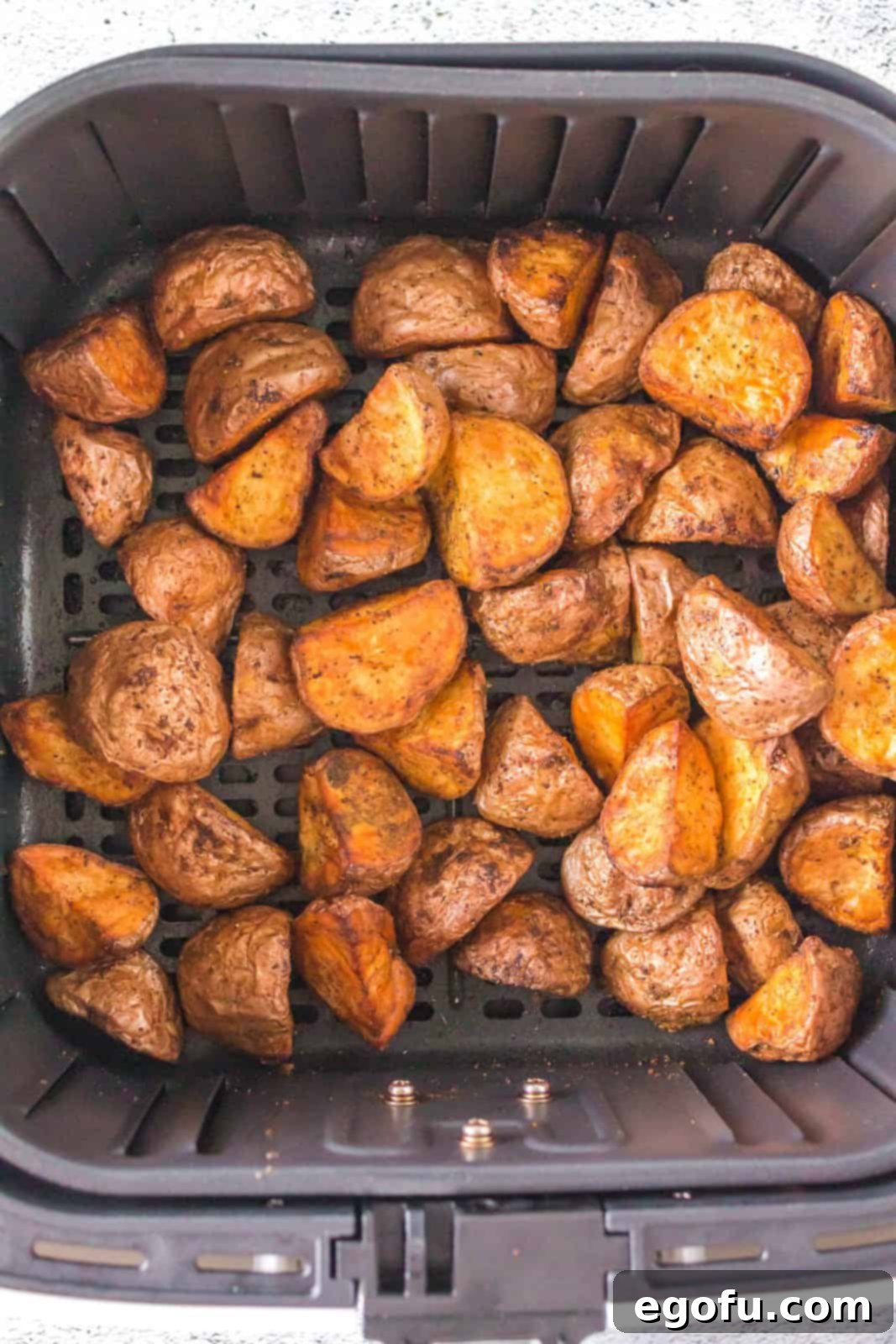 Finished, perfectly roasted Air Fryer Red Potatoes, golden and crispy, sitting in the air fryer basket.