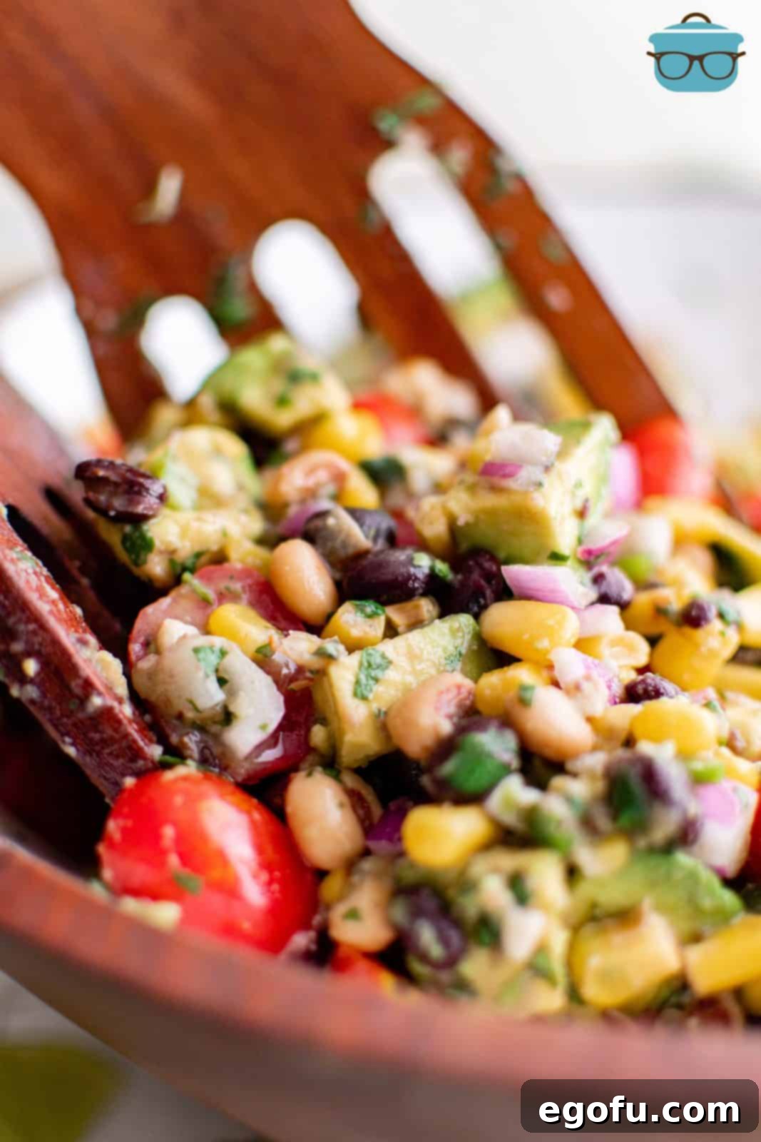 Western Whimsey Dip 2 Vibrant Cowboy Caviar in a rustic wooden bowl, ready to be served with a wooden spatula.