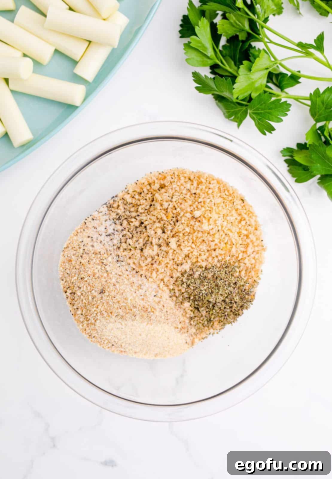 Panko, breadcrumbs, Italian seasoning, salt, garlic powder, and pepper added to bowl.