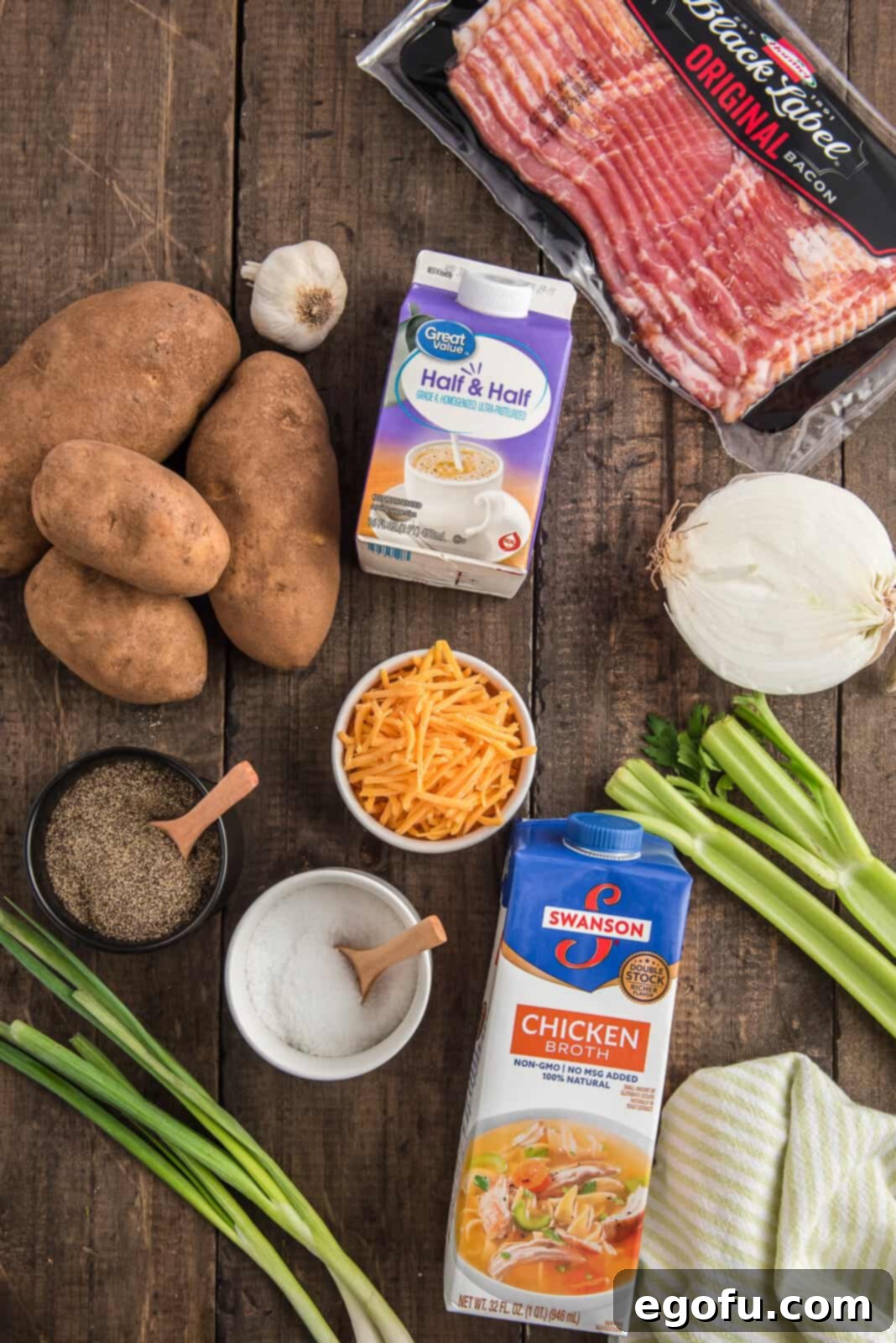 Slow Cooker Creamy Potato Bliss 11 All the essential ingredients for Crock Pot Potato Soup laid out: russet potatoes, diced onion, garlic, celery, chicken broth, salt and pepper, half and half, with toppings of bacon, shredded cheese, and green onions.