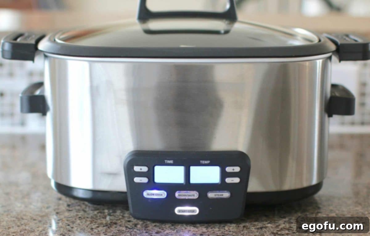 Slow Cooker Creamy Potato Bliss 6 A black, oval slow cooker sits on a kitchen counter, patiently transforming simple ingredients into a comforting potato soup.
