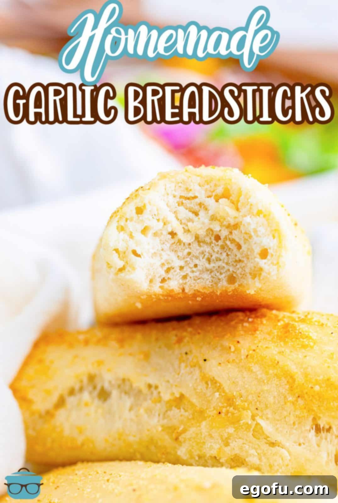 closeup photo of three breadsticks stacked and the top breadstick has a bite taken out of it. 