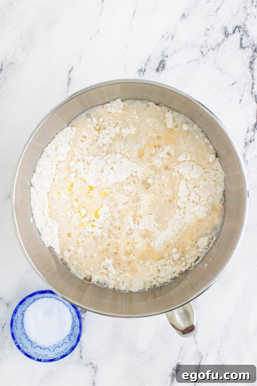 yeast mixture added to flour mixture in a mixing bowl.