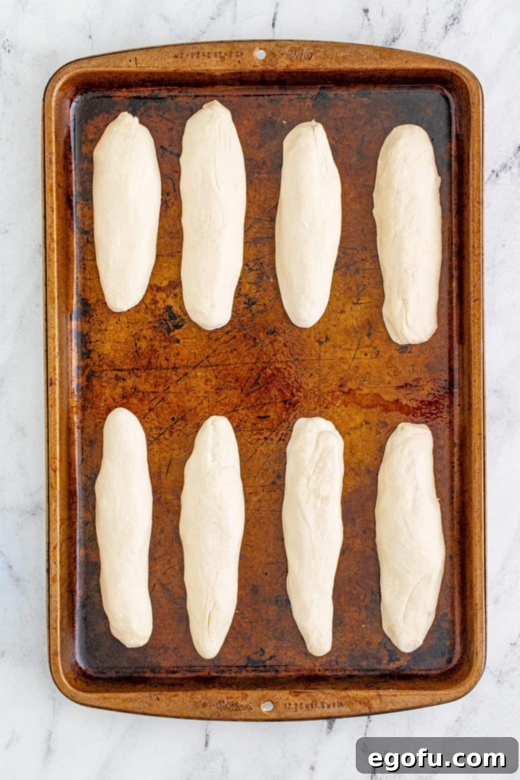 rolled breadsticks on a baking sheet.