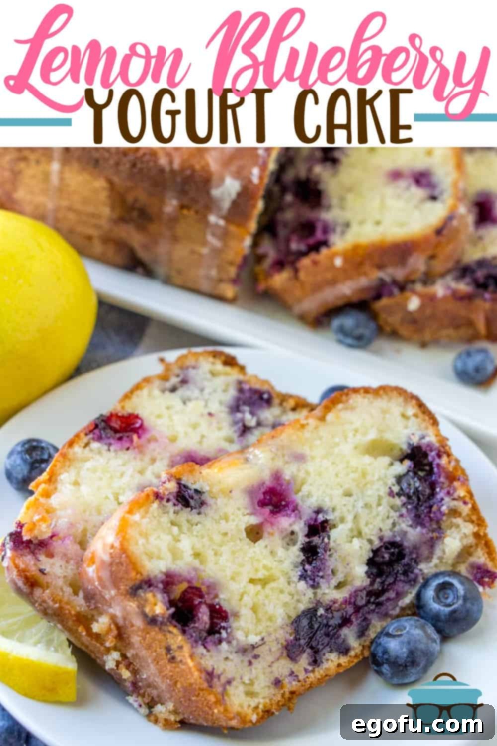 Lemon Blueberry Yogurt Cake recipe from The Country Cook. Closeup of two slices of cake on a white plate surrounded by fresh blueberries and slices of lemon.