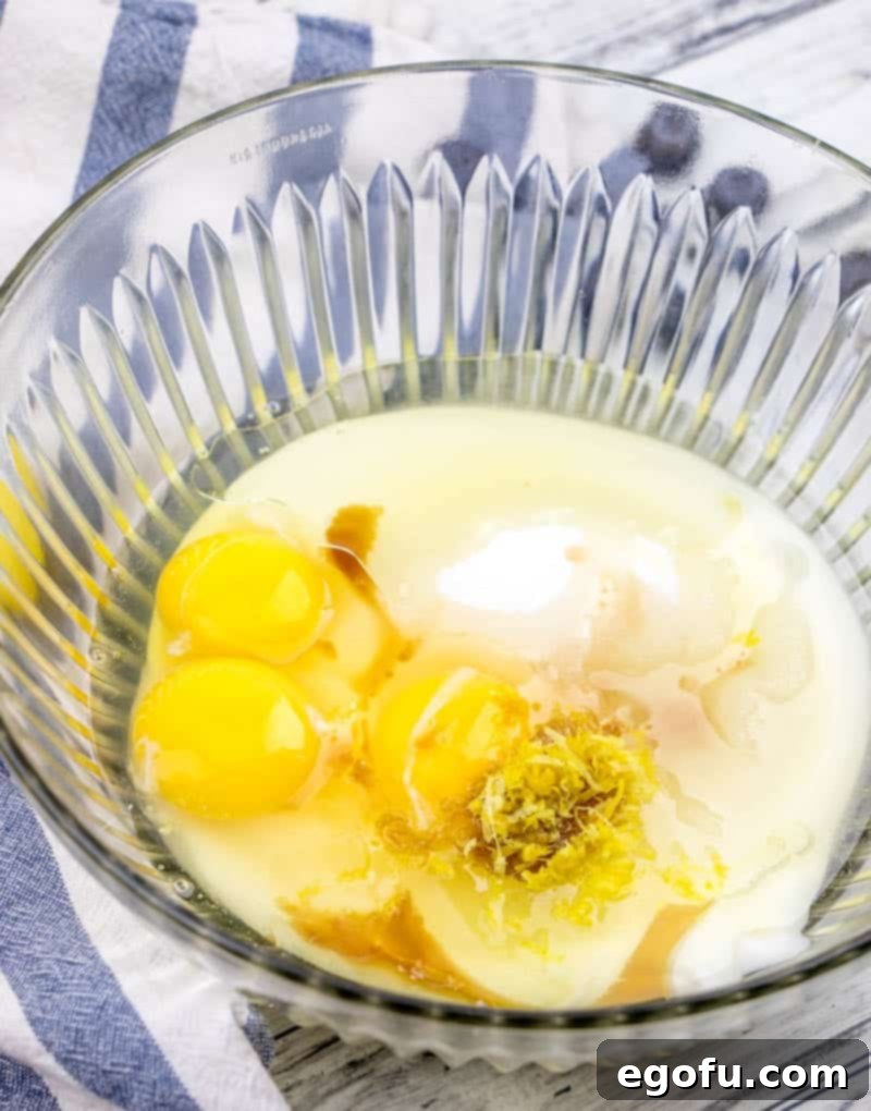 yogurt, sugar, eggs, lemon zest, vanilla extract stirred together in a bowl.