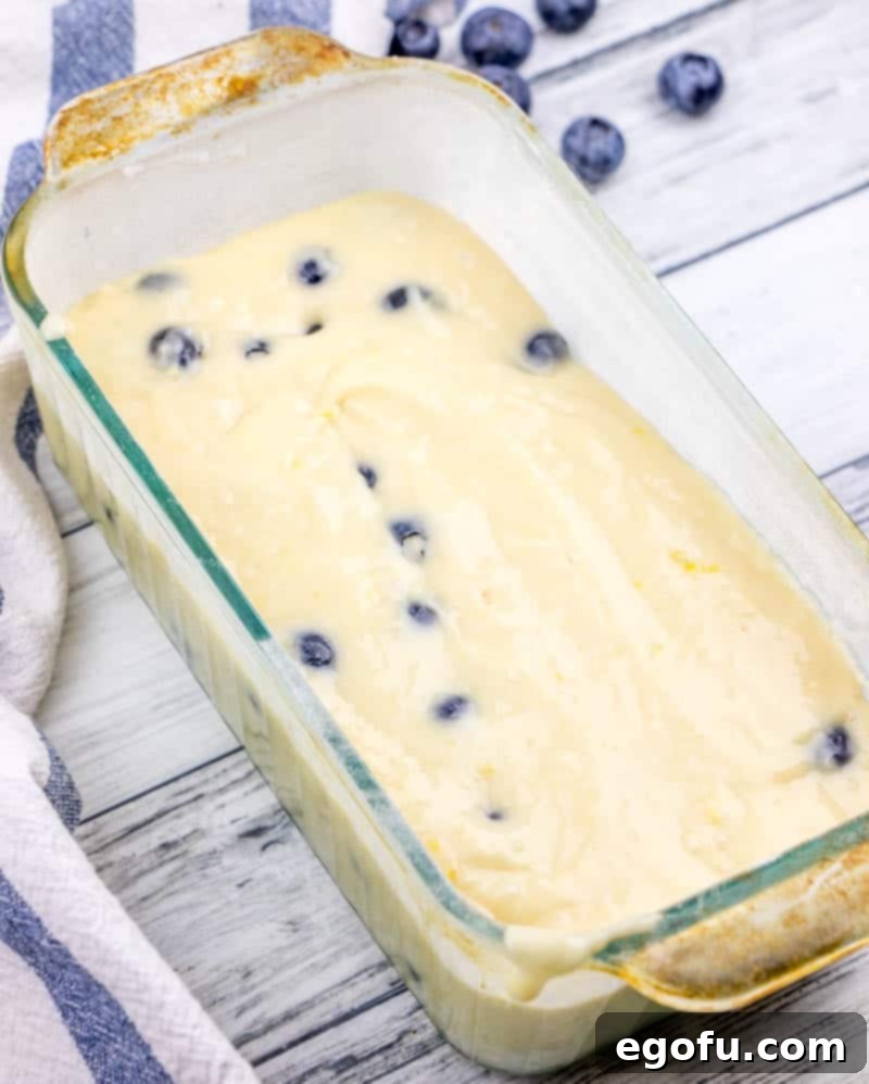 Lemon Blueberry Yogurt Cake Batter poured into loaf baking pan.
