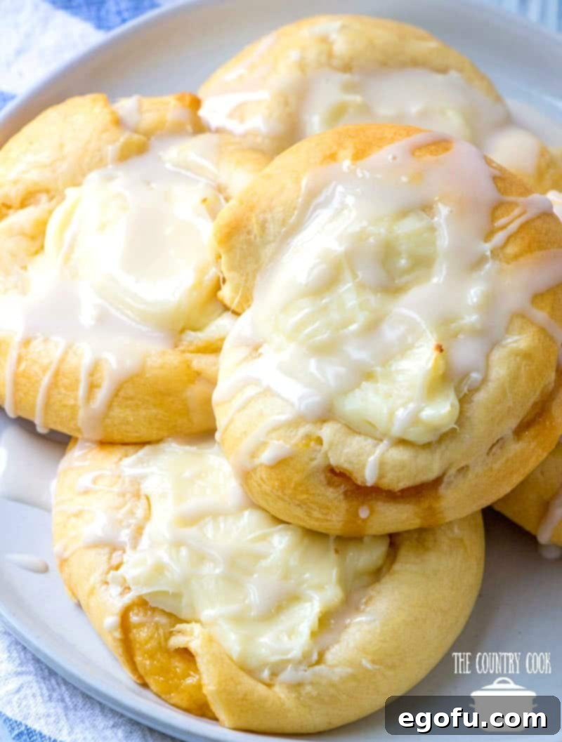 Effortless Cheesy Danishes 11 stack of cheese danishes on a round white plate.