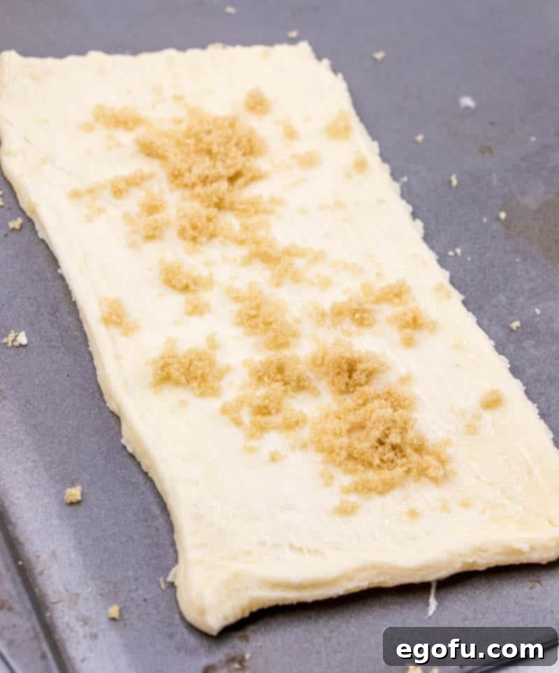 Effortless Cheesy Danishes 7 light brown sugar sprinkled on crescent roll dough.