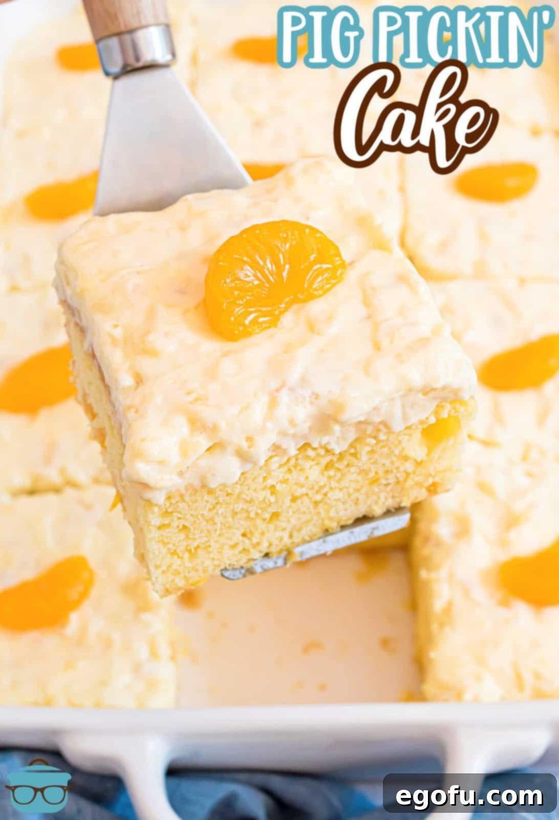 Pineapple Mandarin Ambrosia Cake 3 A pristine slice of Pig Pickin Cake being gently lifted out of a 9x13 inch baking dish with a white spatula, showcasing its layers and fluffy topping.
