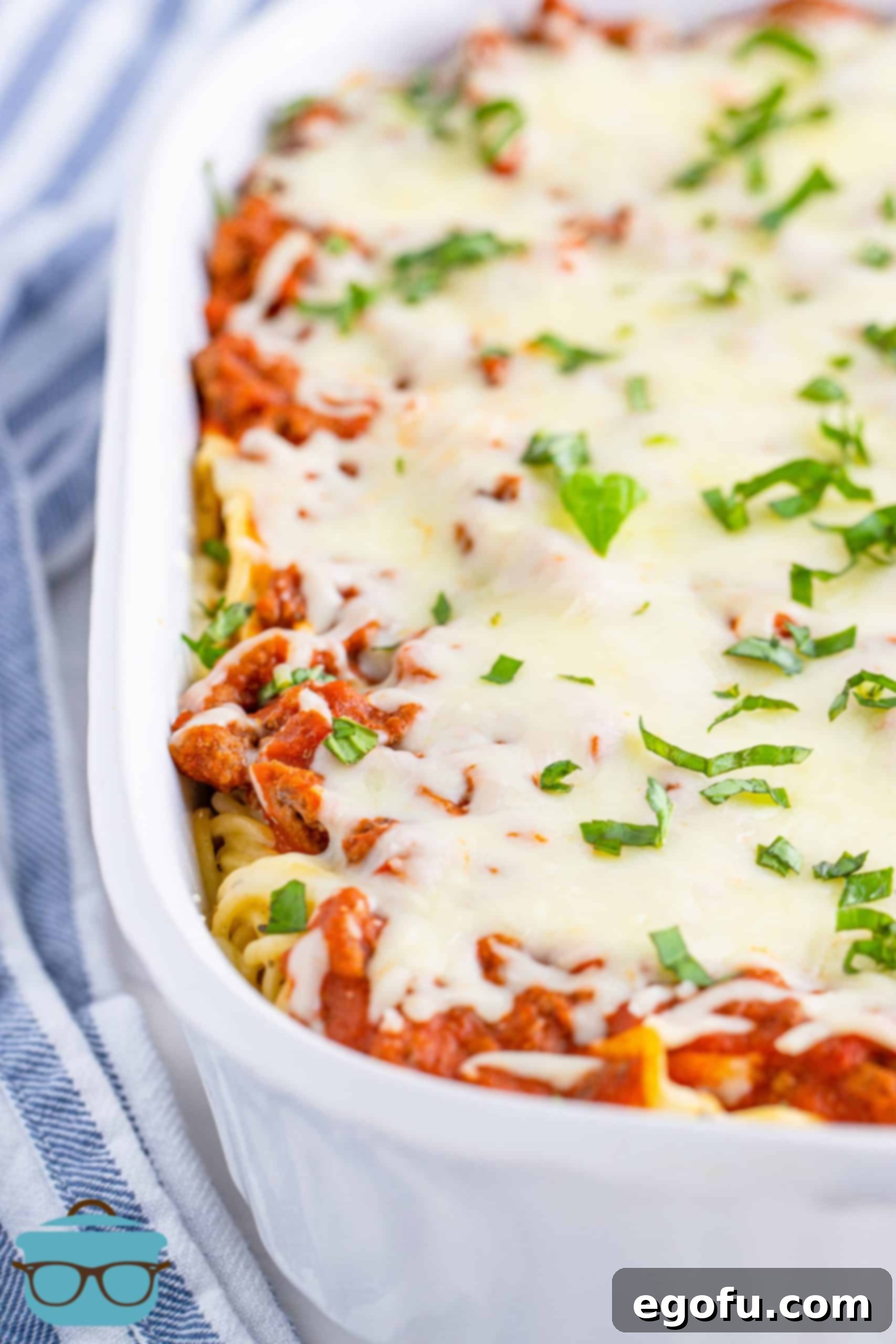 Fully cooked baked spaghetti shown in a white baking dish, fresh out of the oven.