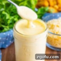 A spoon holding a scoop of Homemade Caesar Dressing, illustrating its rich, creamy texture.