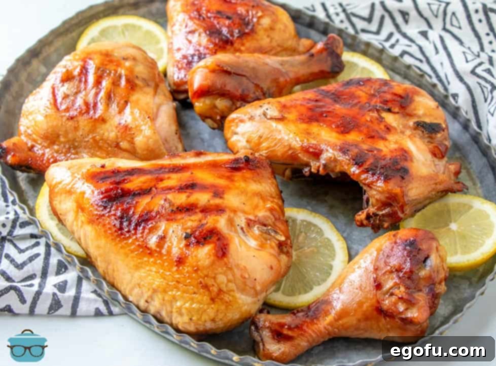 pieces of HULI HULI chicken on a metal platter with slices of lemon scattered about.