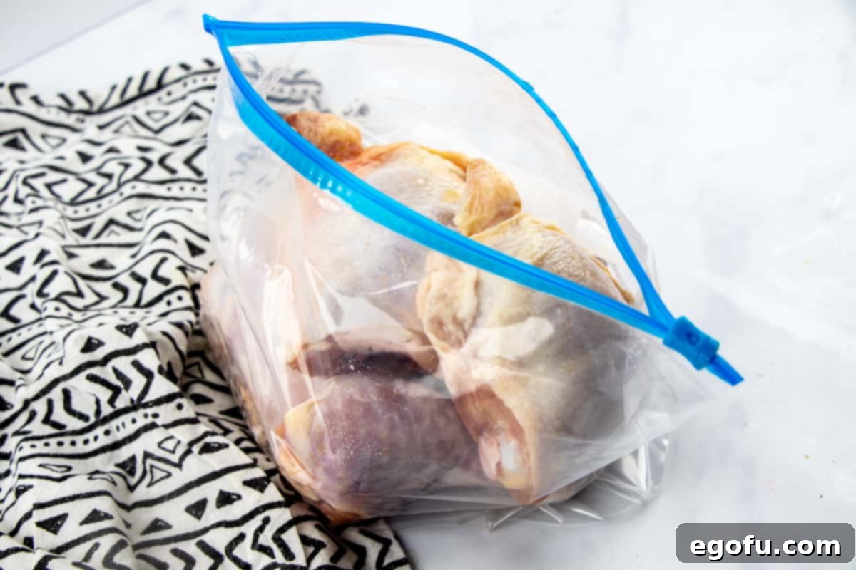 chicken parts marinating in Huli Huli chicken sauce in a ziploc bag.