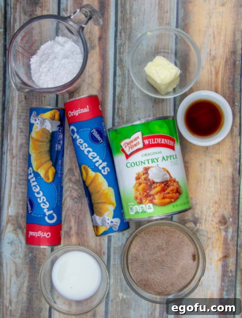 Golden Apple Danish Pastries 4 Individual ingredients for crescent roll apple danishes laid out: crescent rolls, apple pie filling, vanilla extract, sugar, cinnamon, butter.