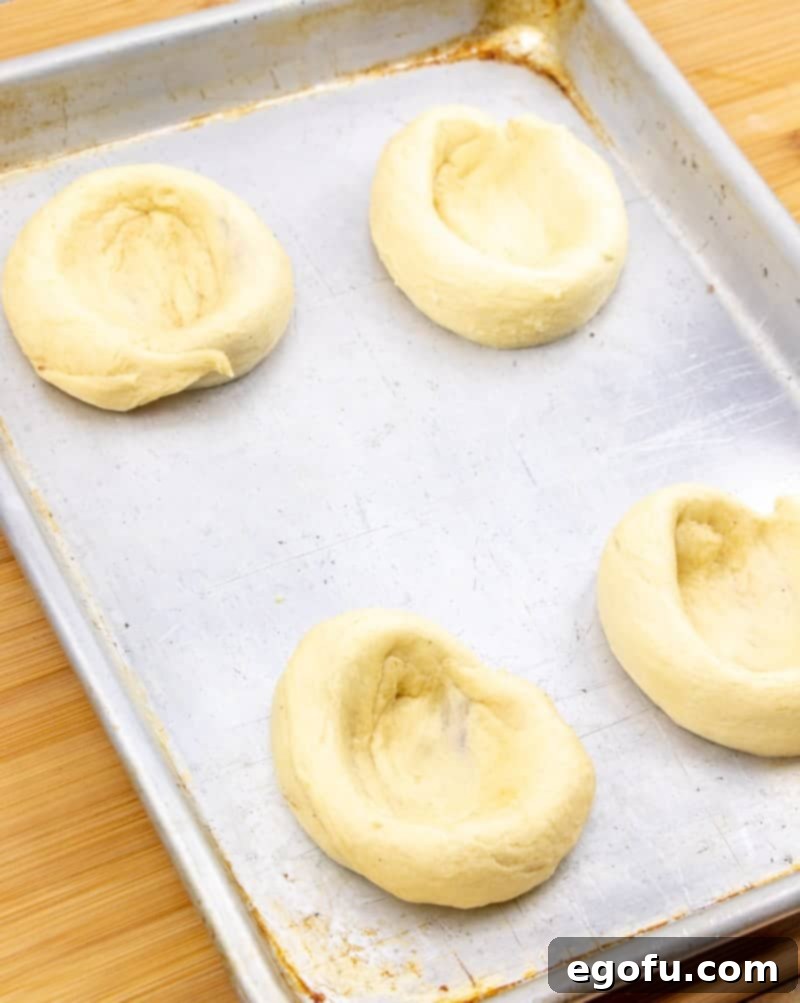 Golden Apple Danish Pastries 8 Crescent roll danish dough spread apart in the center on a baking sheet, creating a well for the filling.