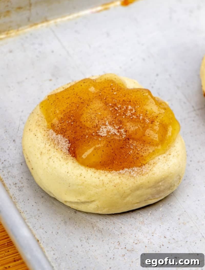 Golden Apple Danish Pastries 10 Apple pie filling placed on top of crescent roll dough spirals, ready for baking.
