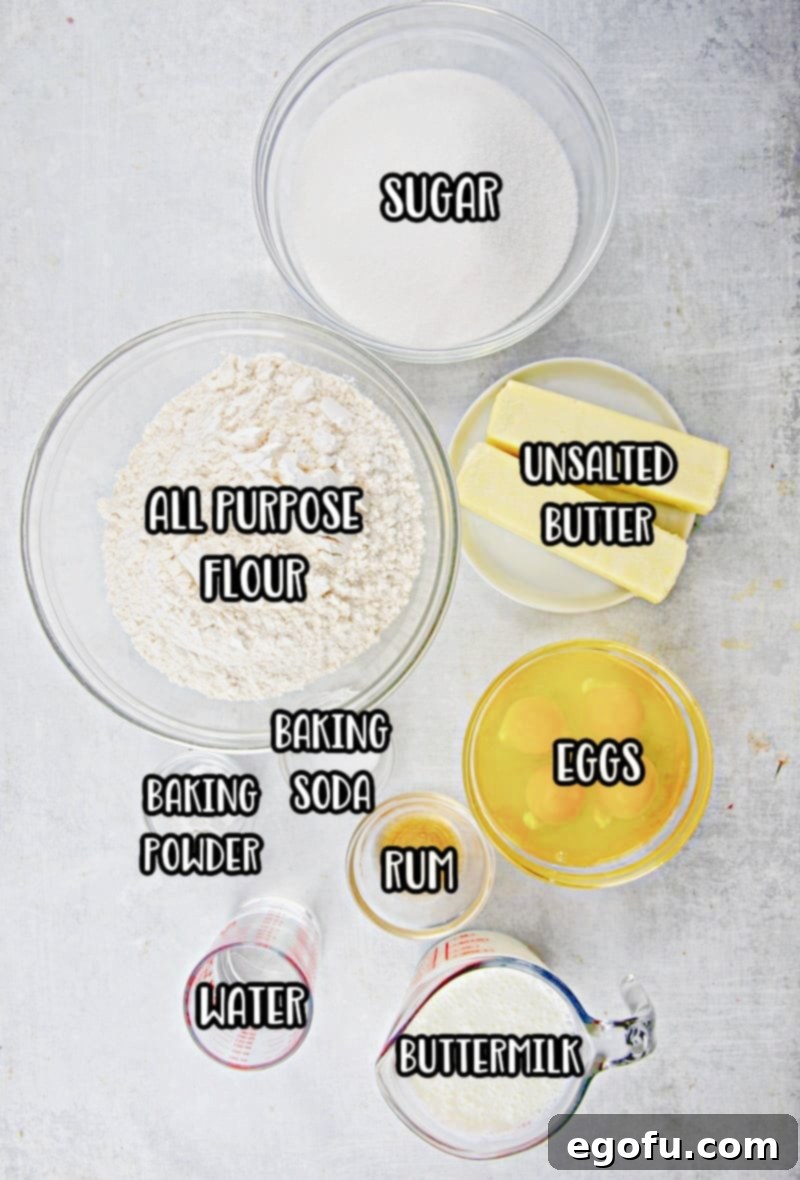 Kentucky Butter Cake 5 Various ingredients for Kentucky Butter Cake laid out: sugar, eggs, unsalted butter, rum, buttermilk, all-purpose flour, salt, baking powder, baking soda, and water.