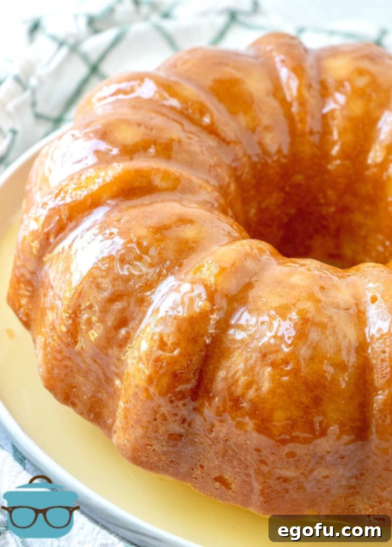 Kentucky Butter Cake 9 A fully baked and glazed Kentucky Butter Cake on a white plate, ready to be served.