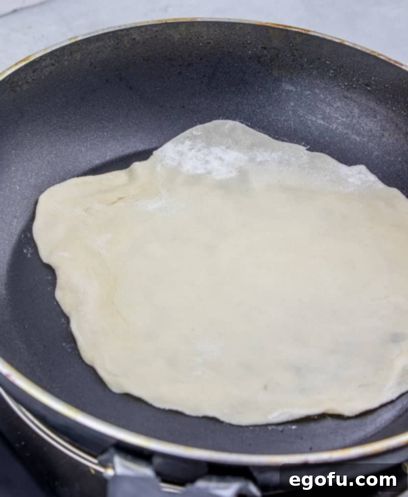 Soft Homemade Flour Tortillas 8 cooking homemade flour tortillas in a nonstick skillet, showing the puffing process.