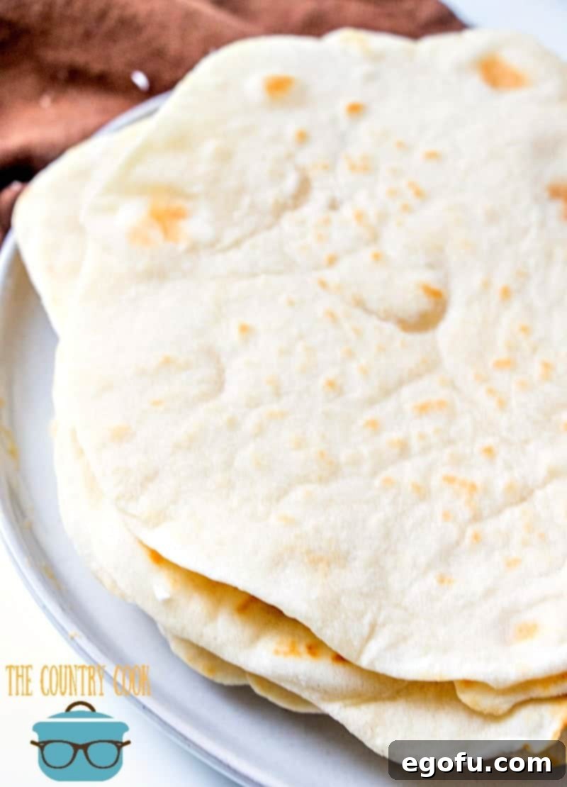 Soft Homemade Flour Tortillas 10 easy light and fluffy homemade flour tortillas shown close up on a plate, highlighting their delicate surface and soft texture.
