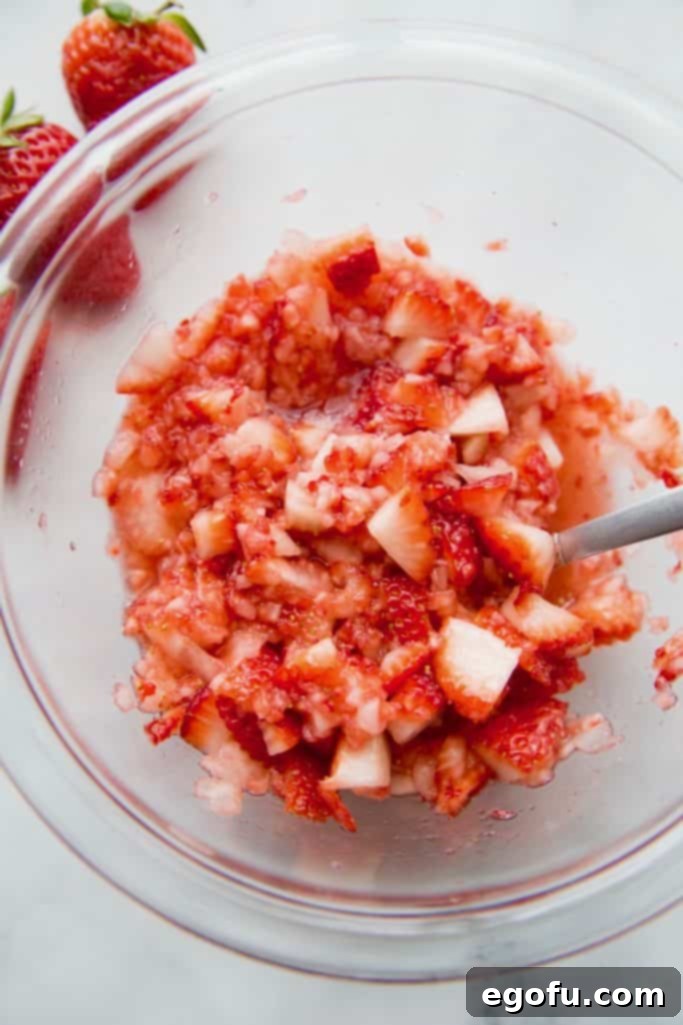 mashed strawberries in a clear glass bowl.