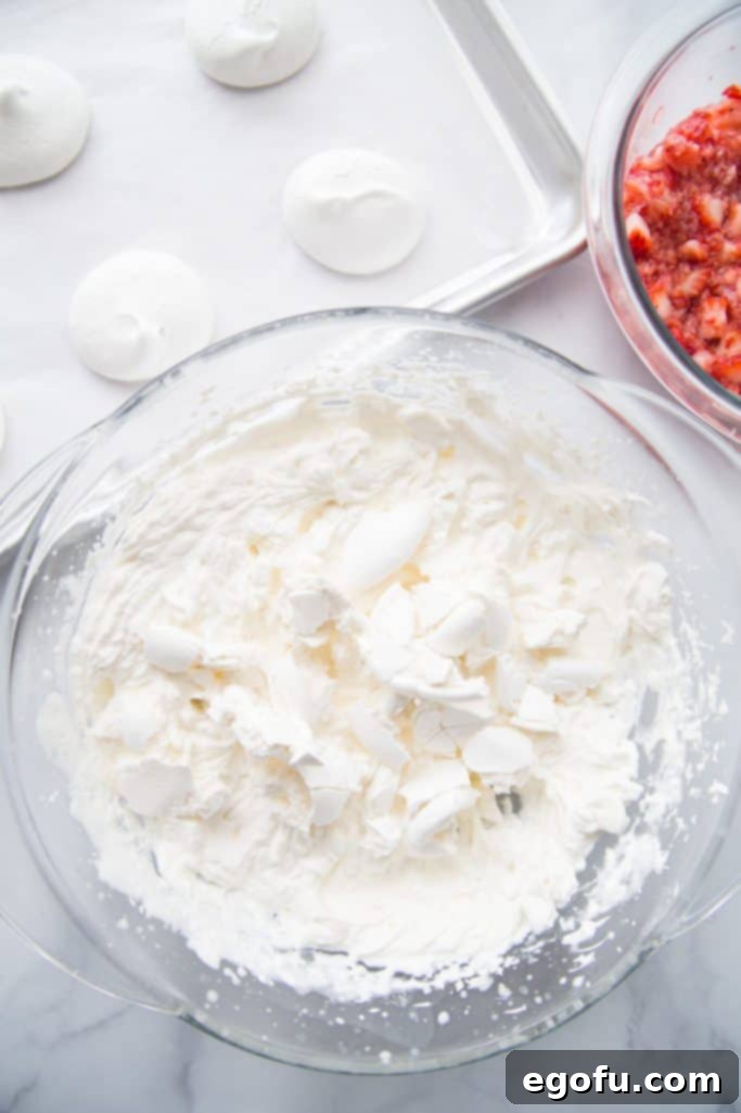 fresh whipped cream and crushed meringue cookies in a glass bowl.