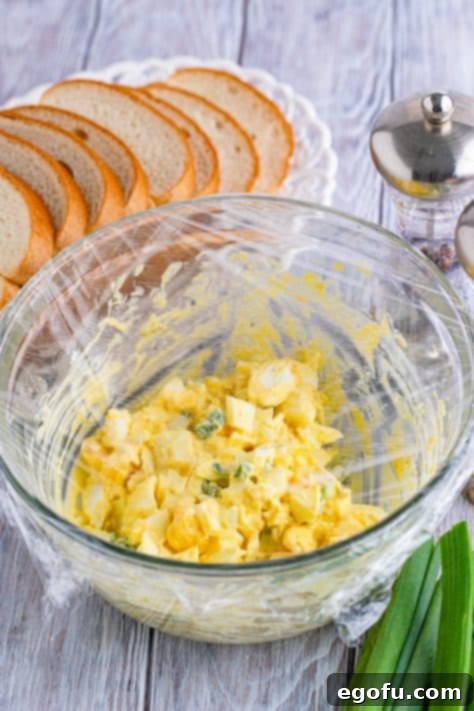 Irresistible Homemade Egg Salad 11 bowl of egg salad covered in plastic wrap.