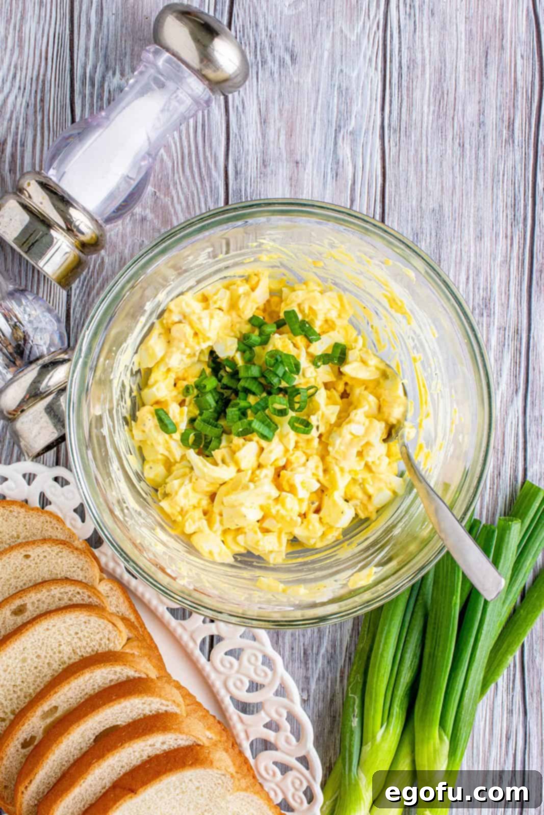 Irresistible Homemade Egg Salad 6 Thinly sliced green onions are stirred into the creamy egg salad in a bowl, adding fresh flavor and color.
