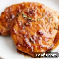 Two Honey Garlic Pork Chops on a white plate.