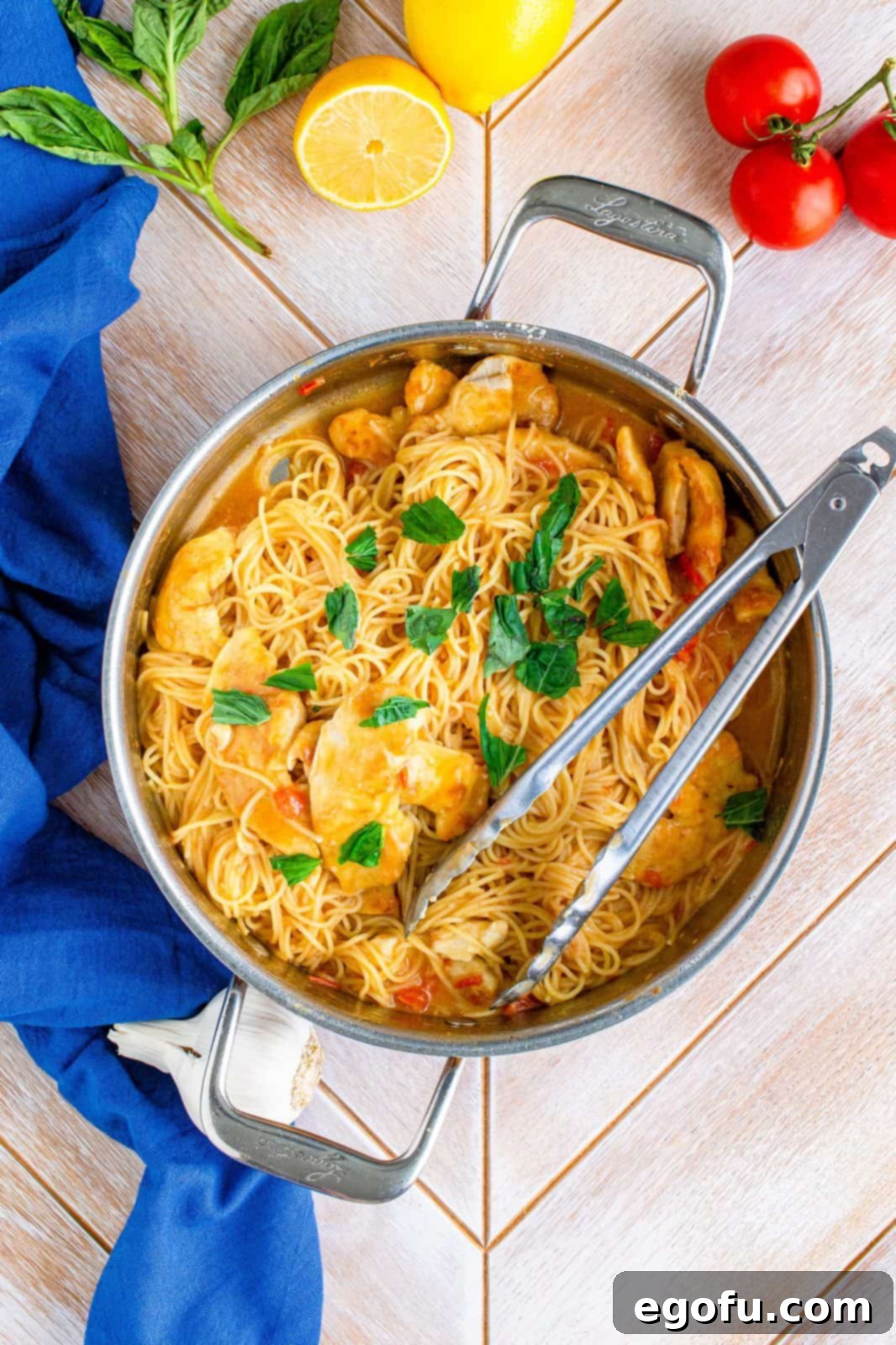 Basil added to finished pasta in pan.