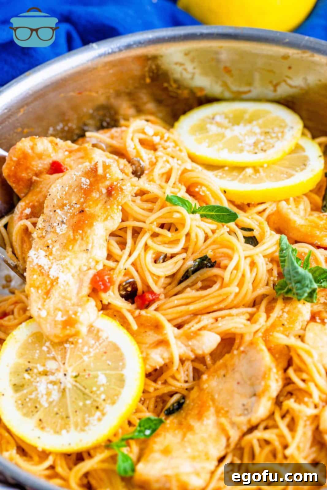 Finished Lemon Chicken Pasta in pan with basil and lemon slices.