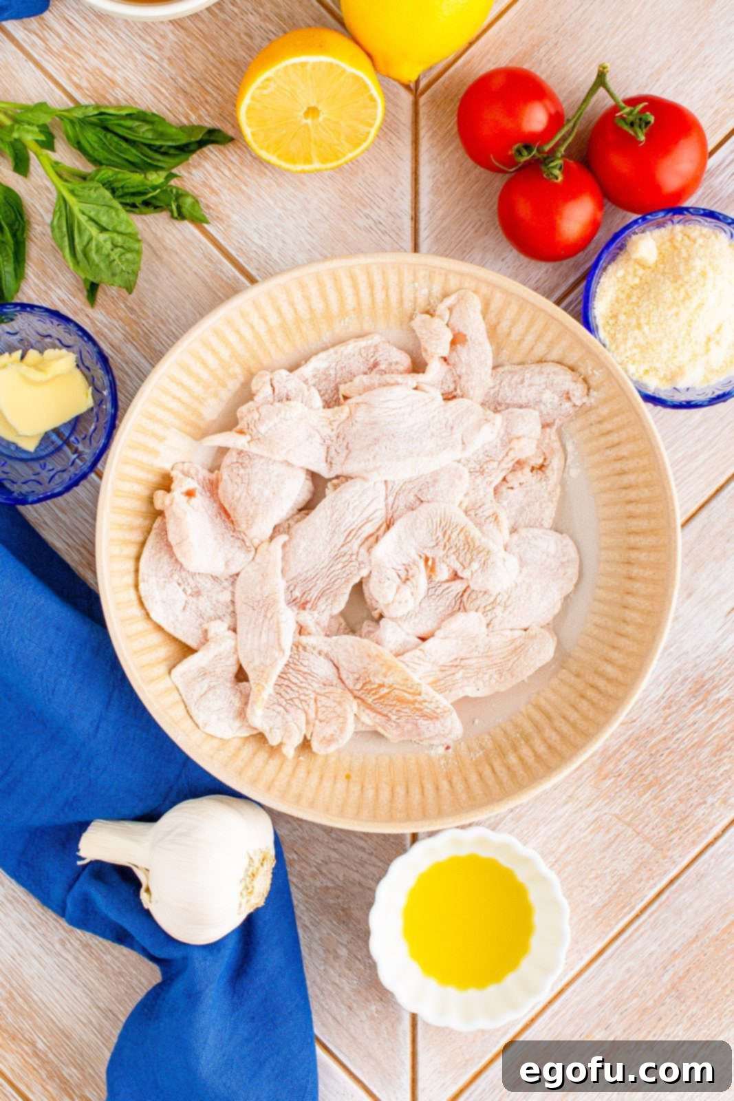 Chicken pieces coated in flour, salt and pepper in bowl.