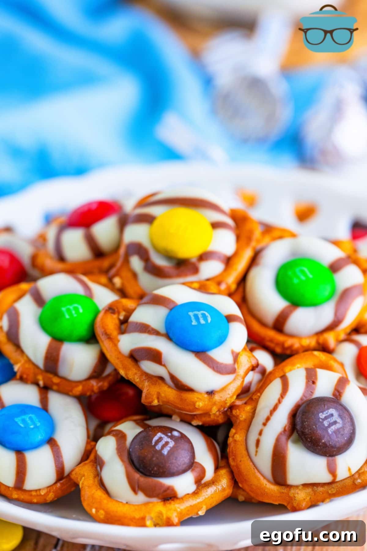 Close up looking at a pile of Hershey Kiss Pretzels, showcasing their perfect blend of chocolate, pretzel, and M&M.
