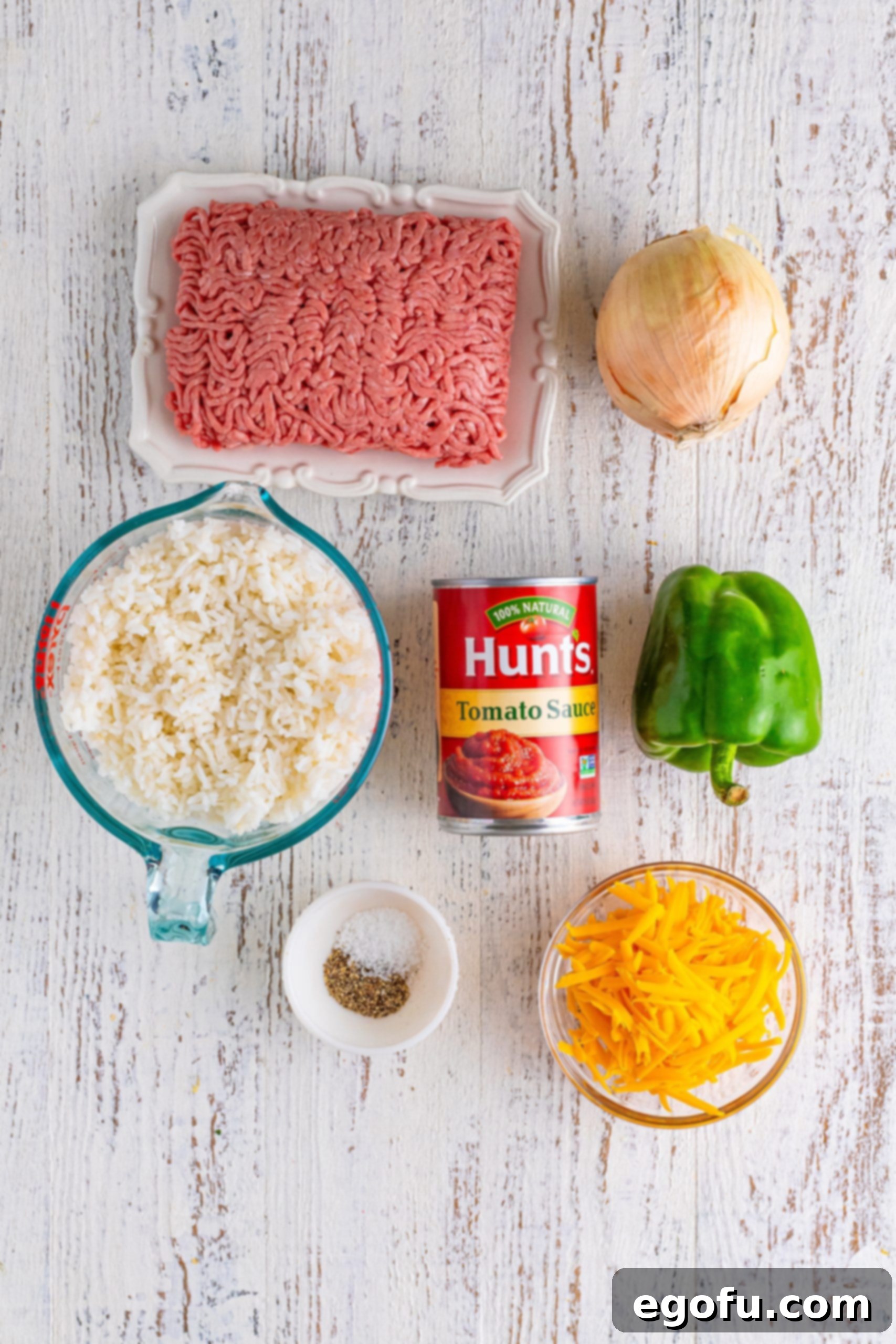 Homemade Spanish Rice 4 Ground beef, rice, tomato sauce, onion, green bell pepper, salt, pepper, and shredded cheese, laid out as ingredients.