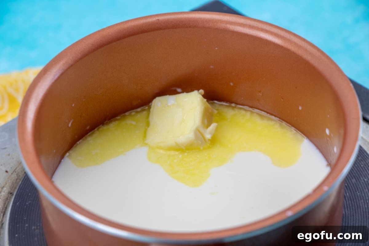 Milk and butter melting together in a small saucepan over medium heat, crucial for the hot milk technique.