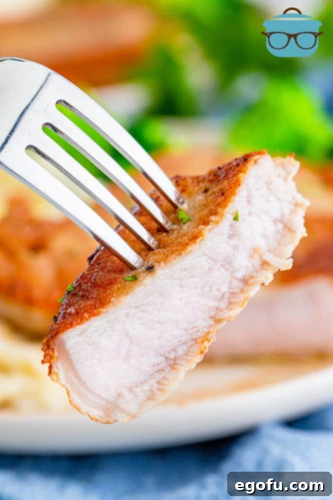 a slice of cooked pork chop shown on a fork.