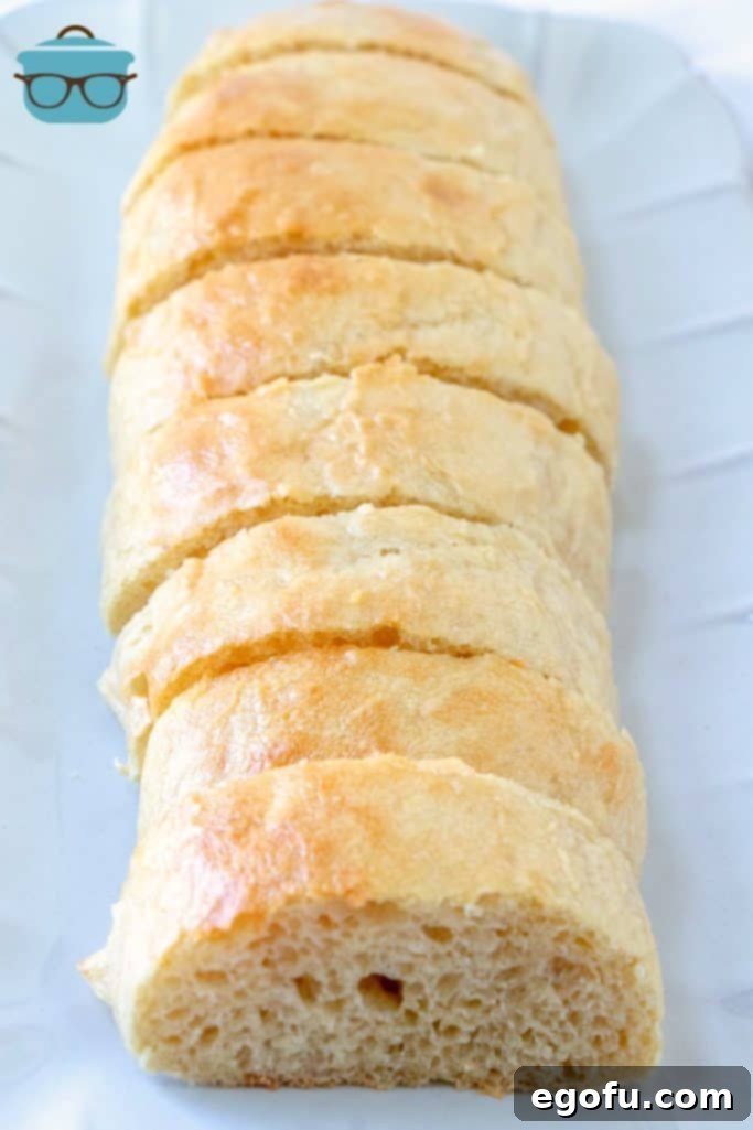 Effortless French Bread Baked Your Way 9 sliced homemade French Bread on a large white serving platter.