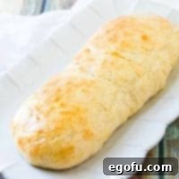Effortless French Bread Baked Your Way 10 roll of homemade French bread on a white platter
