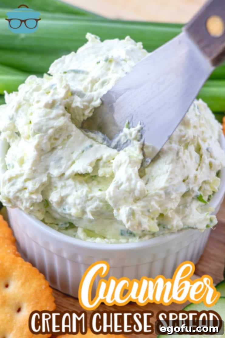 a butter knife inserted into cucumber cream cheese spread in a white bowl.