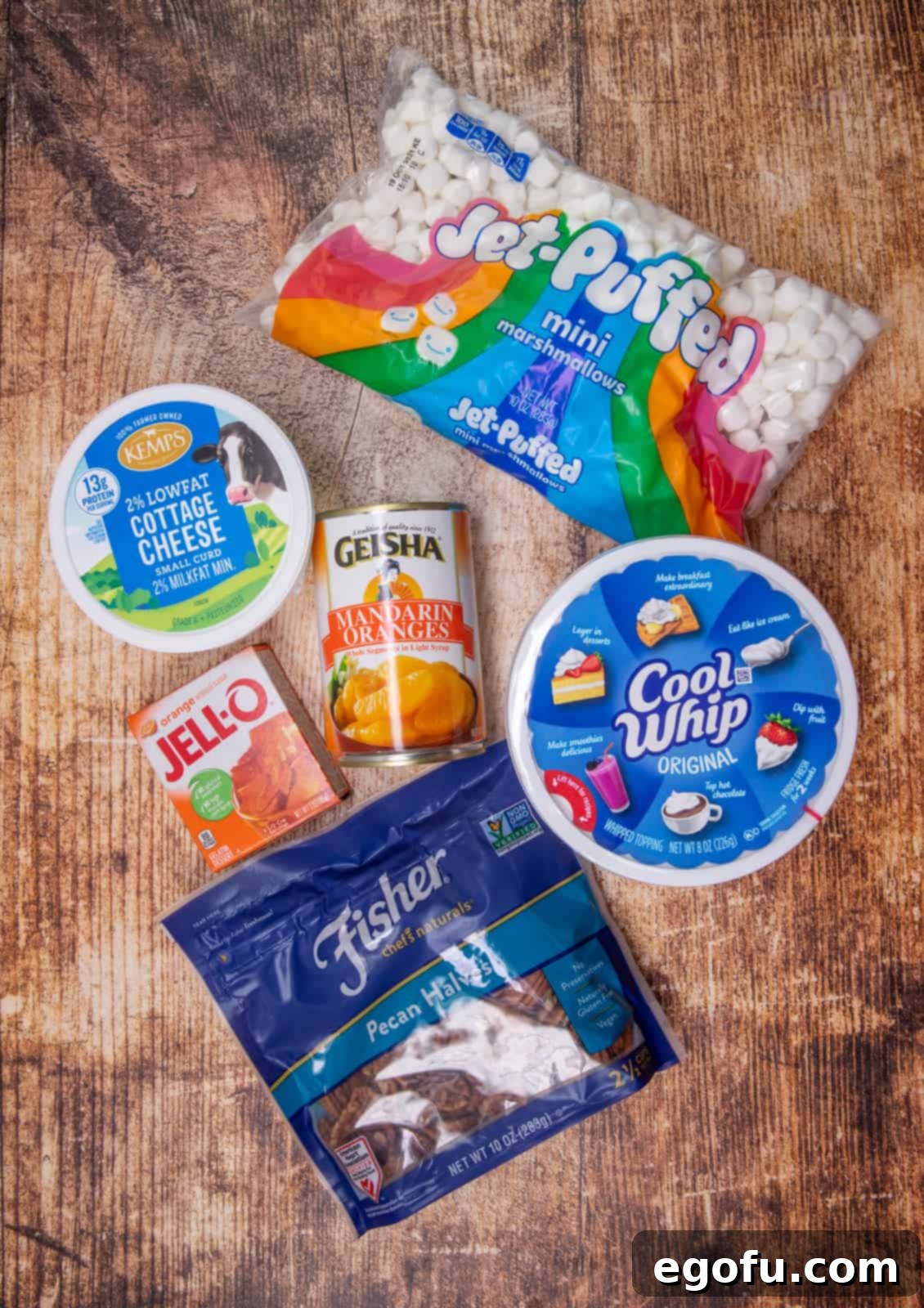 Ingredients needed to make orange fluff: small-curd cottage cheese, orange Jell-O gelatin, mandarin oranges, whipped topping (COOL WHIP), mini marshmallows, chopped pecans.