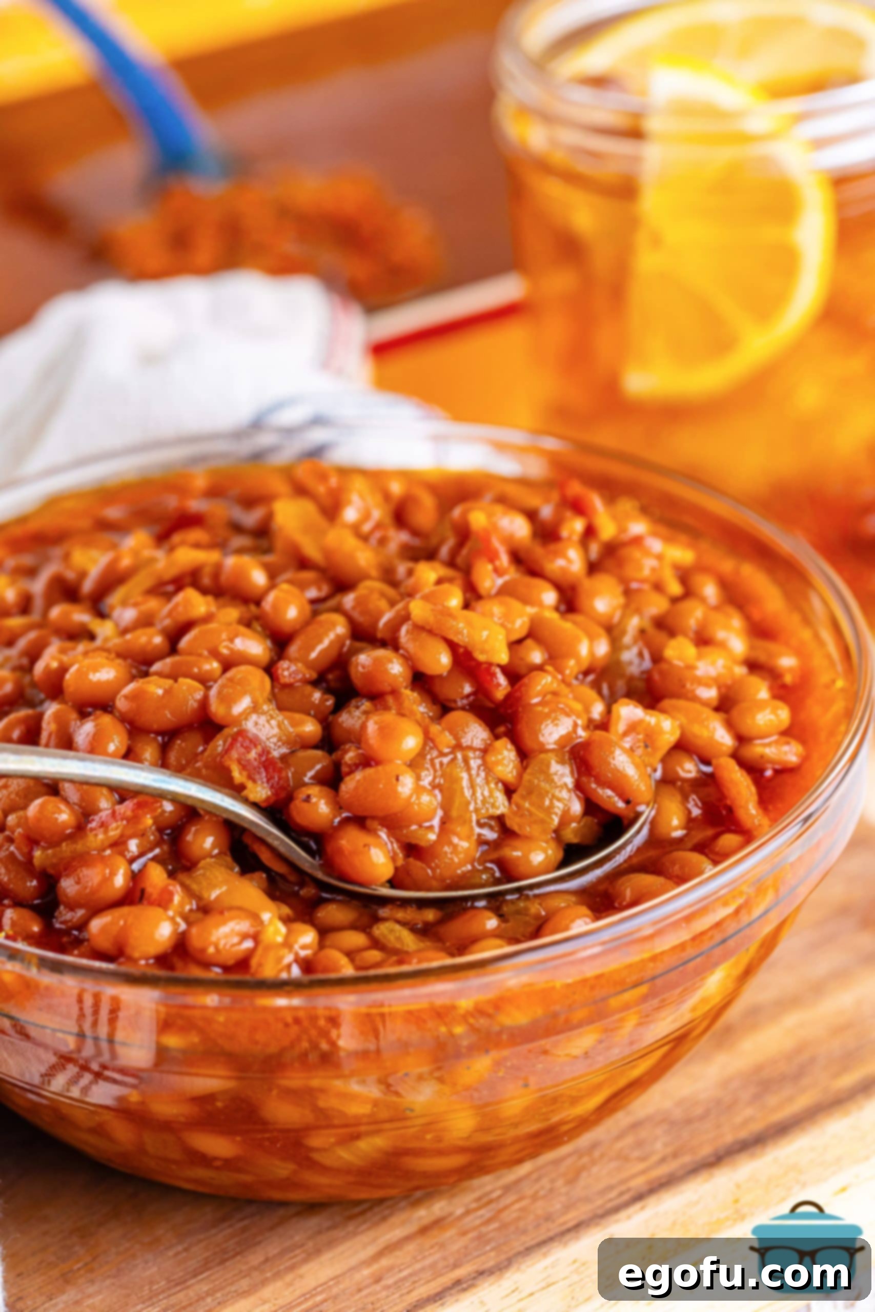 Hearty Comfort Baked Beans 2 A spoon in a large bowl of Southern Baked Beans.