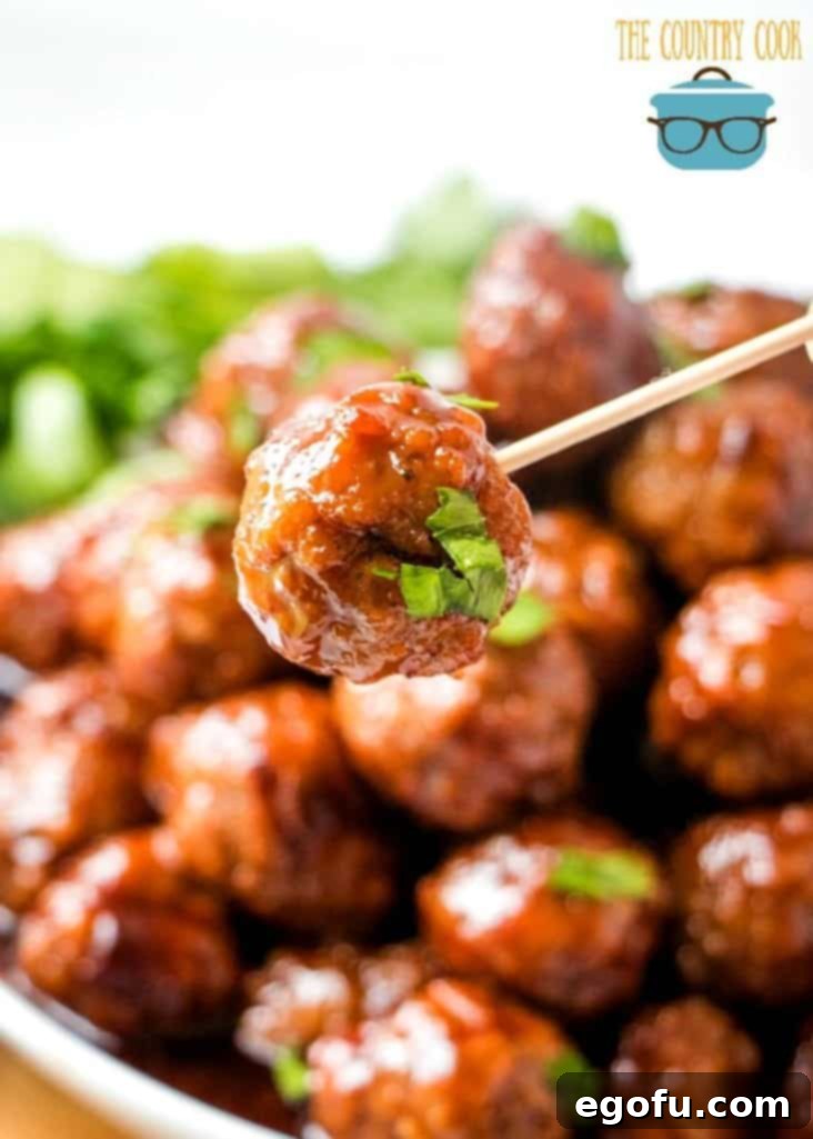 closeup photo of a toothpick holding up a meatball.