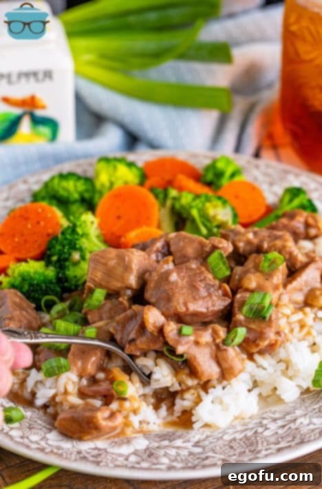 A fork holding a bite of Crock Pot Beef Tips and Gravy.