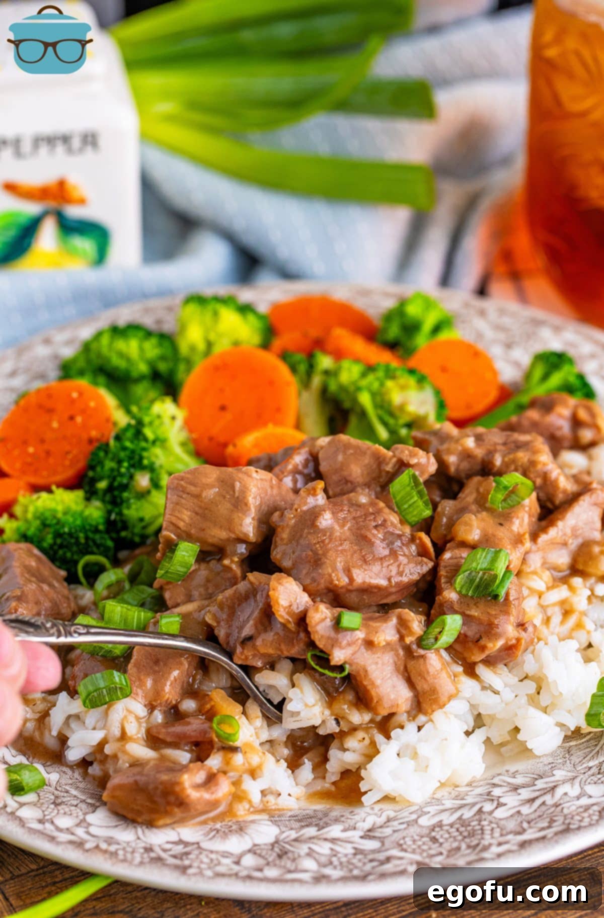 A fork holding a bite of tender Crock Pot Beef Tips and Gravy, showcasing its delicious texture.