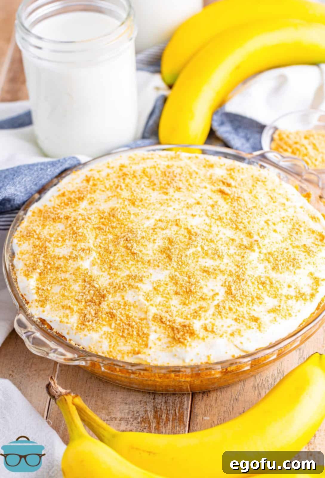 Golden Banana Dream Pie 12 A stunning shot of the fully finished Banana Pudding Pie, artfully surrounded by fresh banana slices, ready to be served.