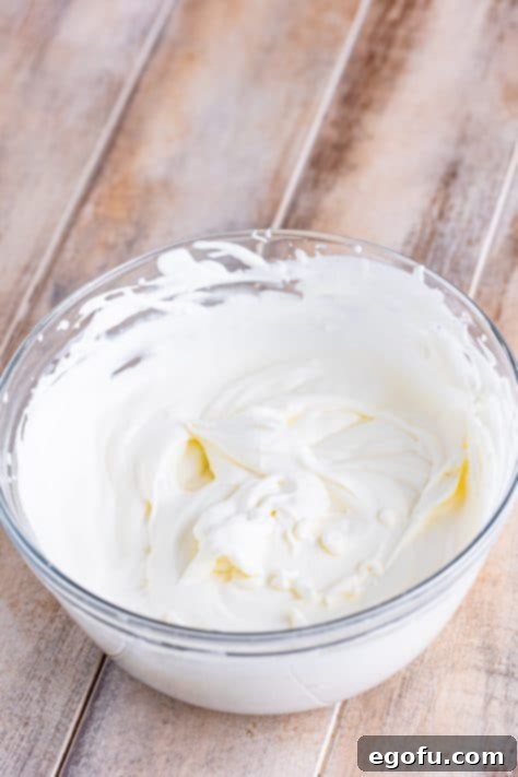 Golden Banana Dream Pie 27 Freshly whipped cream in a large mixing bowl, ready to top the pie.