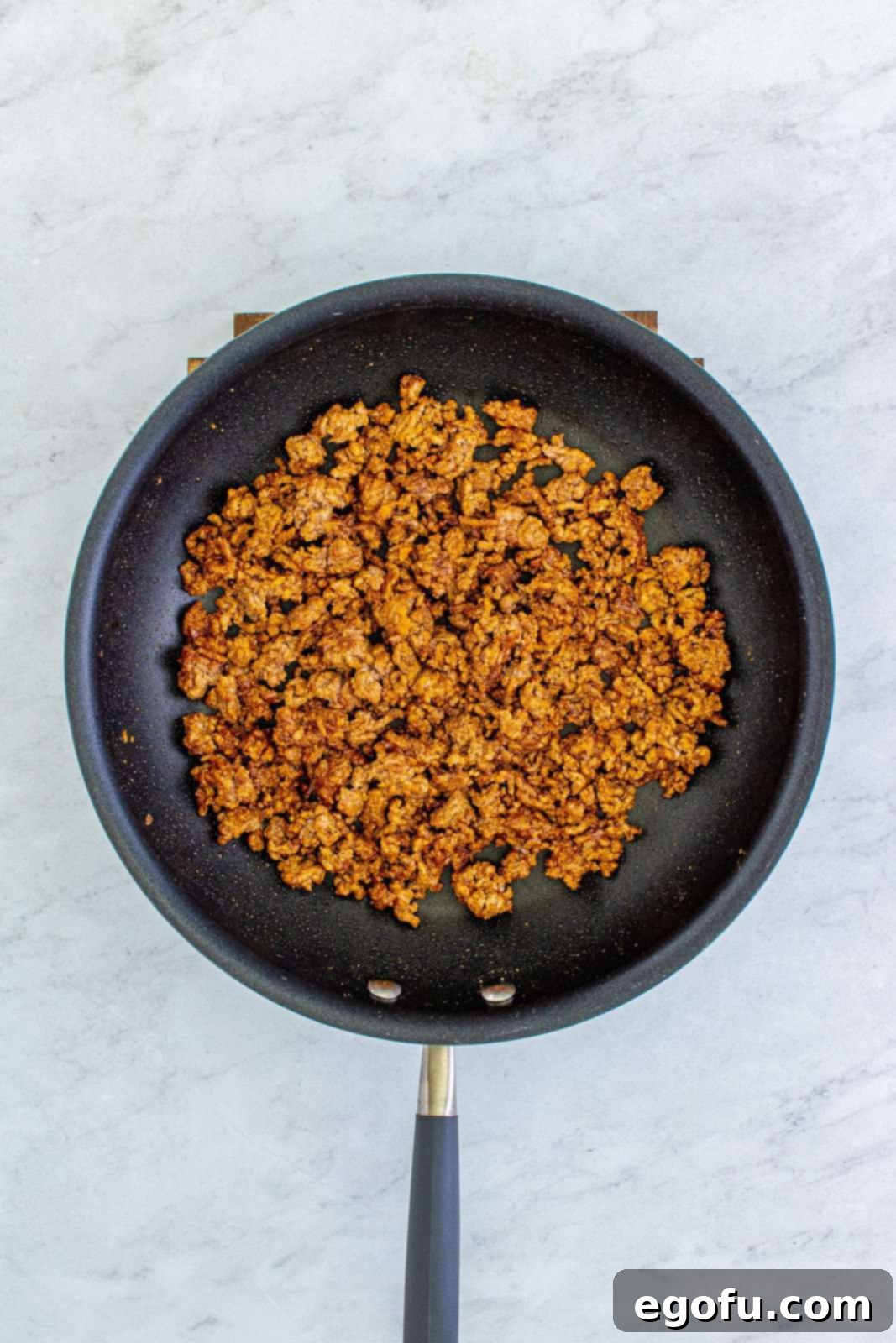 Doritos Fiesta Salad 6 Fully cooked taco meat mixture in a skillet, seasoned and thickened.