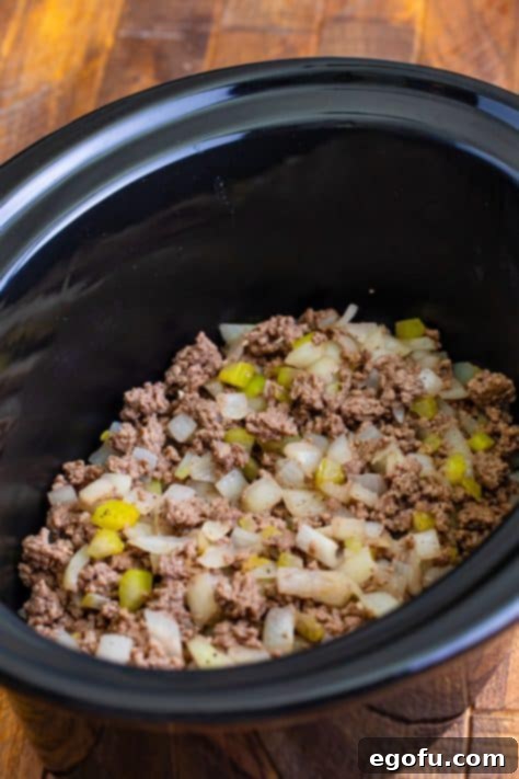 cooked ground beef in the bottom of the slow cooker.
