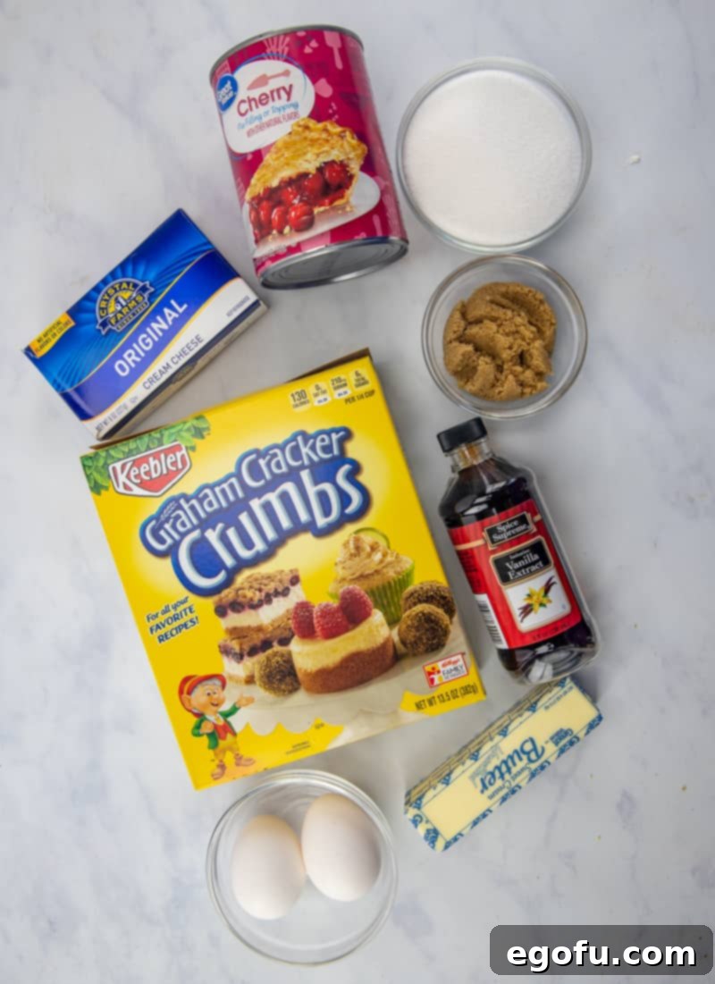 A vibrant flat lay showing all the key ingredients for Cherry Cheesecake Bars: crushed graham crackers, salted butter, light brown sugar, cream cheese, eggs, granulated sugar, and vanilla extract.